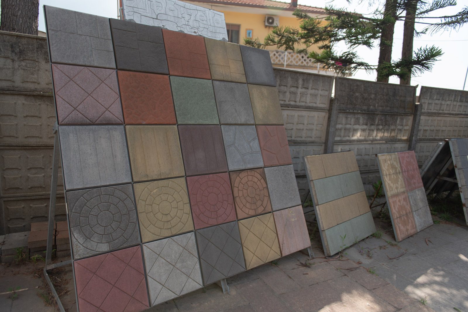 Espositore con mattonelle in cemento di diversi colori, disegni e finiture